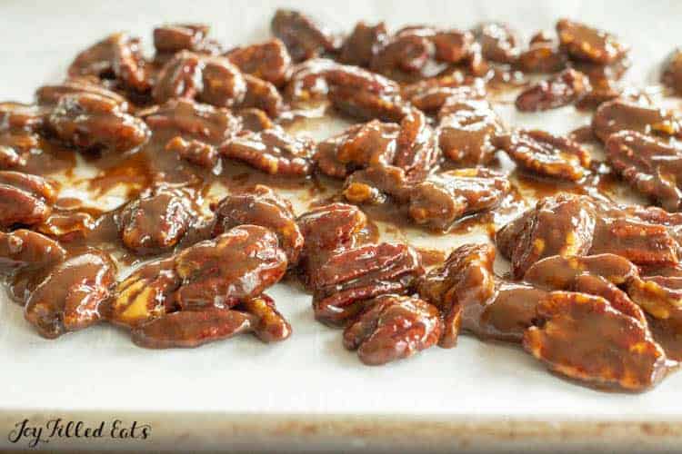 close up of candied pecans on baking sheet