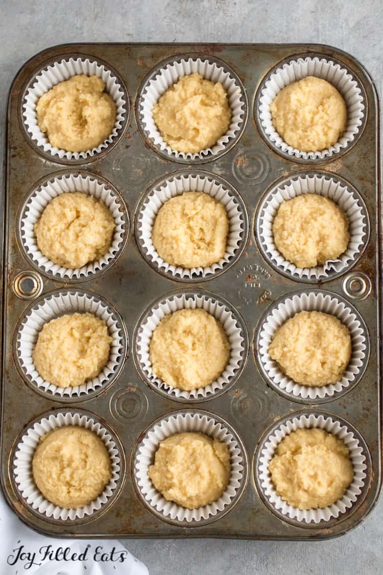 cupcake batter spooned into wrapped lined muffin tin