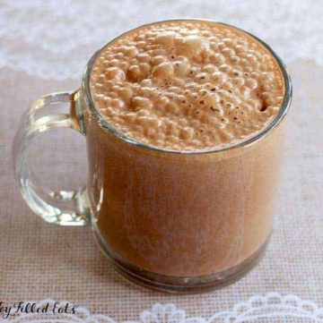 glass mug filled with healthy hot chocolate close up on lace table cloth