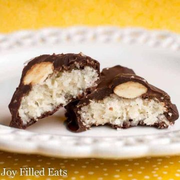 two halves of homemade almond joy candies leaning on each other placed on a white plate
