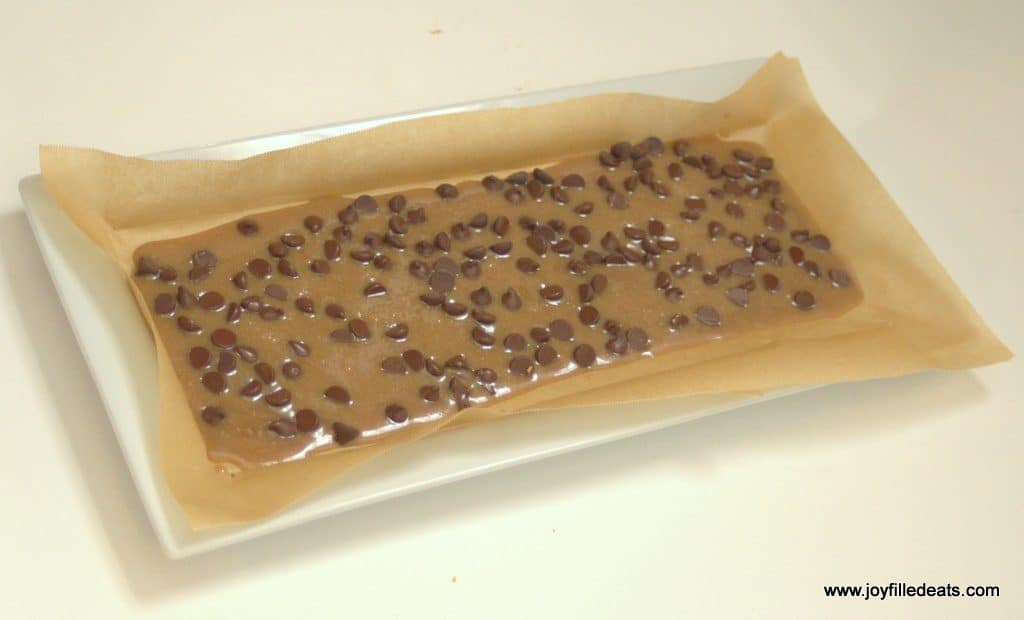 low carb chocolate chip cookie dough bark batter rolled onto a sheet of parchment paper