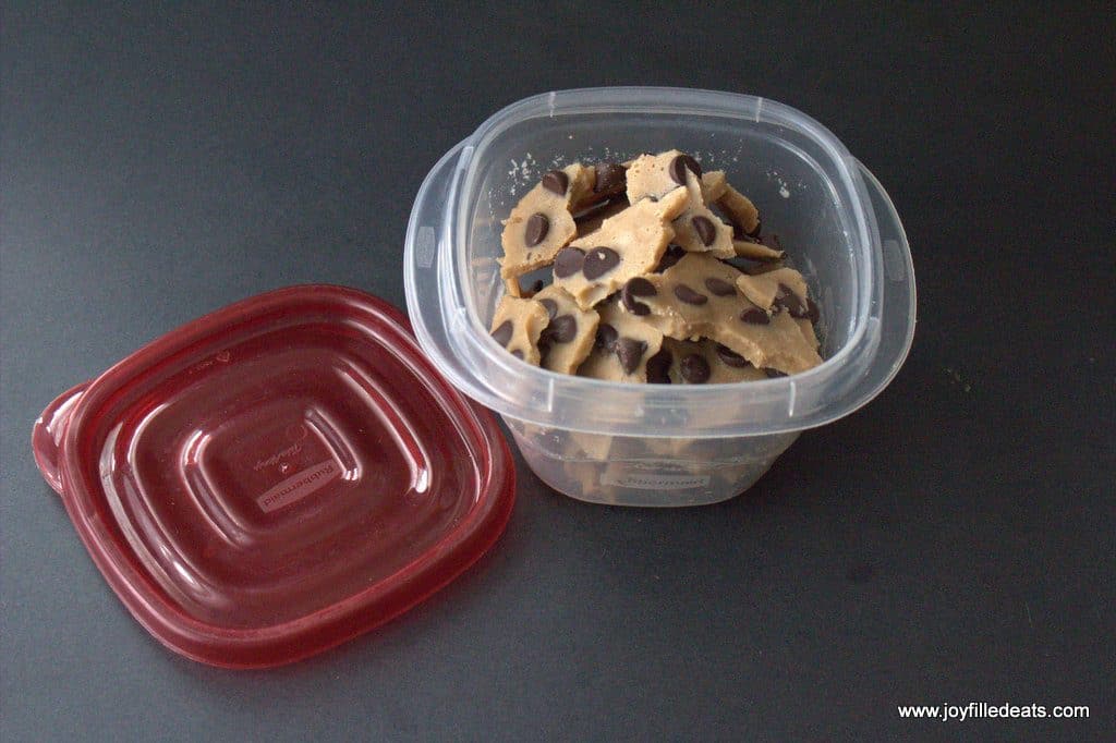 sugar free chocolate chip cookie dough bark pile in a square tupperware container with lid removed