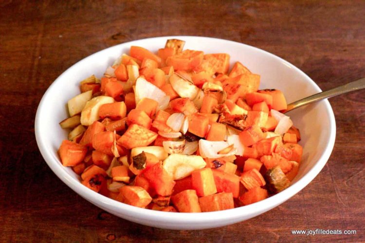 bowl full of roasted root vegetables with a utensil