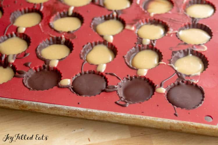 red candy mold filled with salted caramel cups, some with chocolate topping
