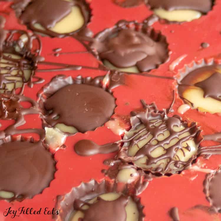 Red candy mold with salted caramel cups being drizzled with a chocolate design topping