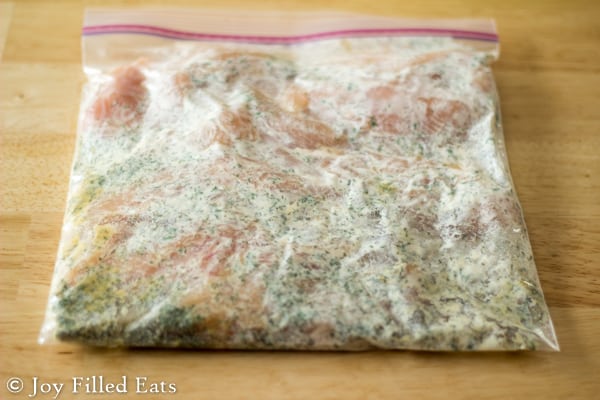 large ziplock bag filled with chicken marinading in a ranch seasoning