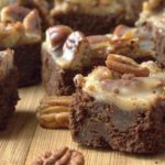 close up of table covered in pecan praline brownies and whole pecans