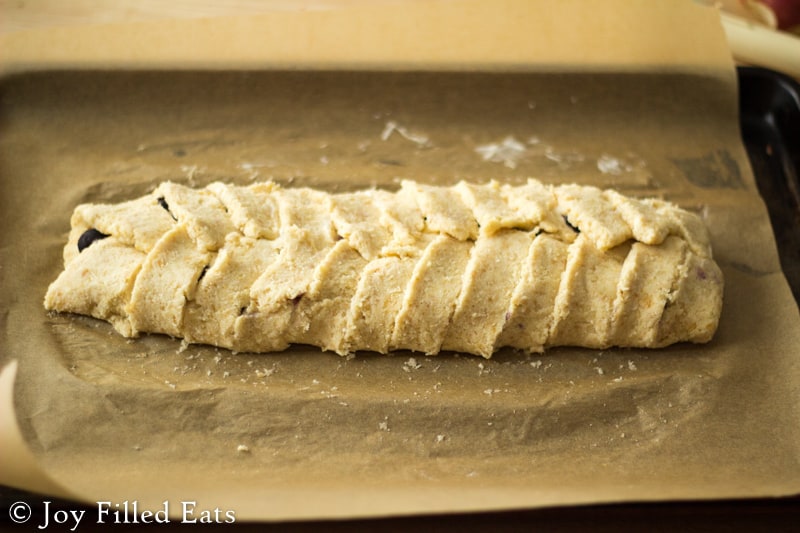 danish dough braided over blueberry and cheese filling on a sheet of parchment paper