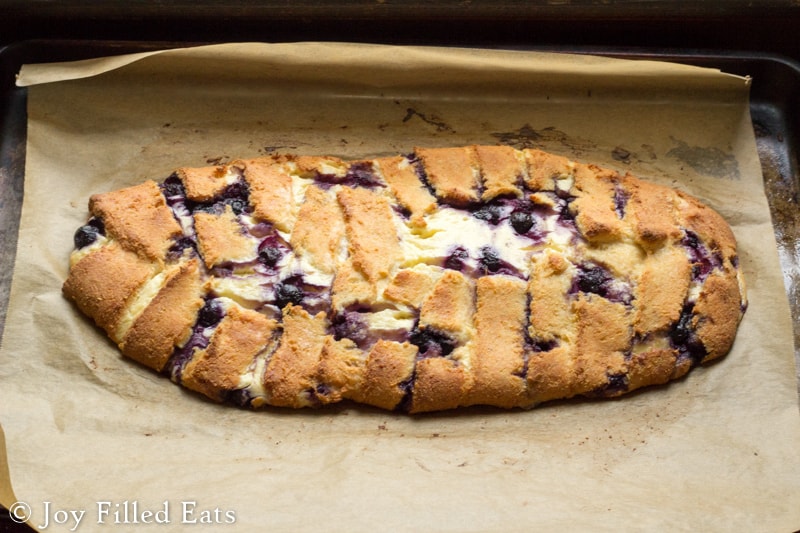 baked braided blueberry cheese danish on a sheet of parchment paper