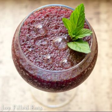 overhead shot of a frozen blueberry mojito in a wide round glass