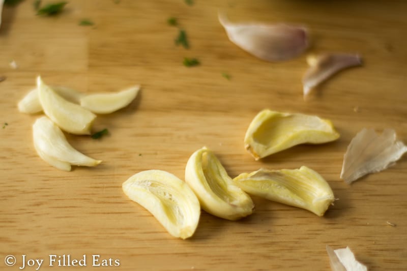 sliced garlic cloves on a cutting board
