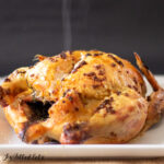 garlic roast chicken on a platter with steam rising