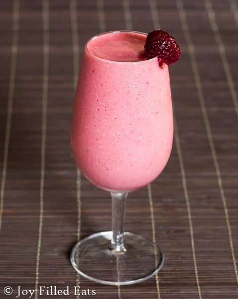 a frozen raspberry cocktail mocktail with a strawberry garnish on the rim