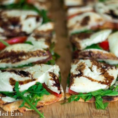 close up on slices of fresh mozzarella & arugula grilled pizza