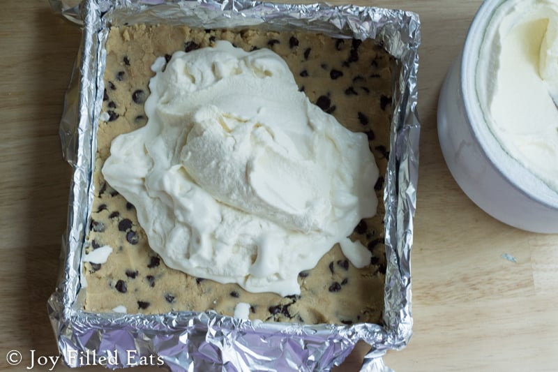 vanilla ice cream poured into center of baking dish with chocolate chip cookie dough base