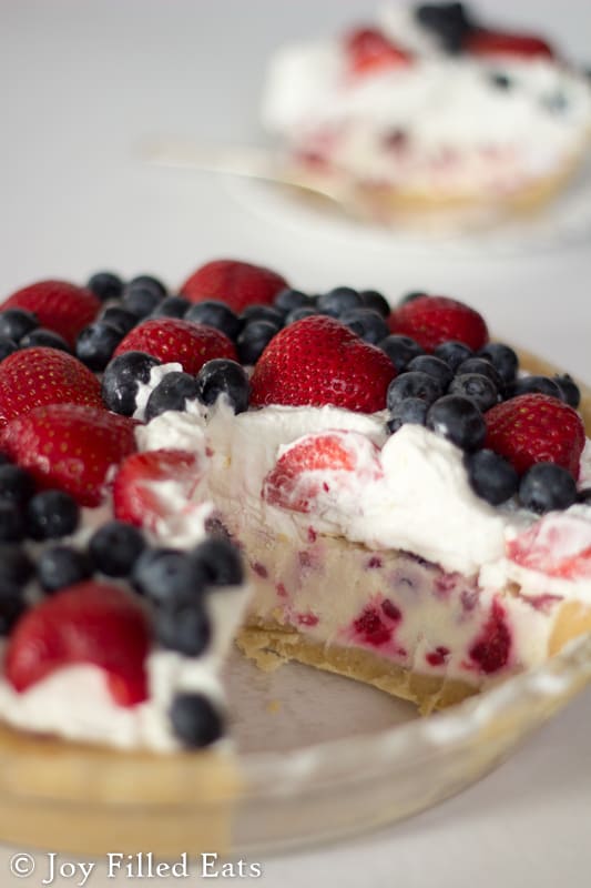 close up on missing slice space to show layers of low carb berries and cream ice cream pie in a glass pie plate