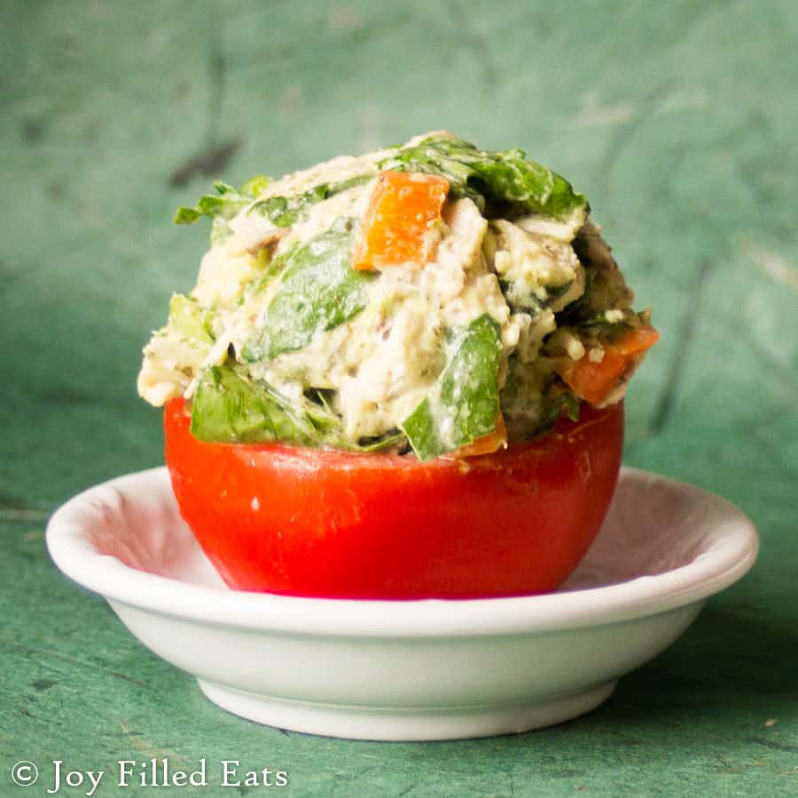 cilantro lime chicken salad filled in a hollowed out tomato half on a white dish