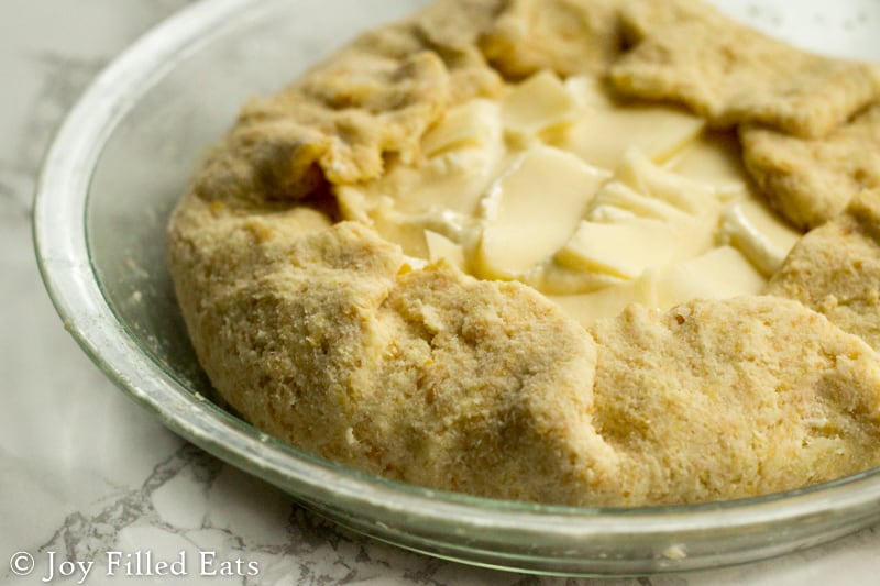 keto cheese calzone pie dough placed in a glass pie dish before baking
