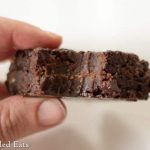hand holding a keto fudge brownie with large bite missing