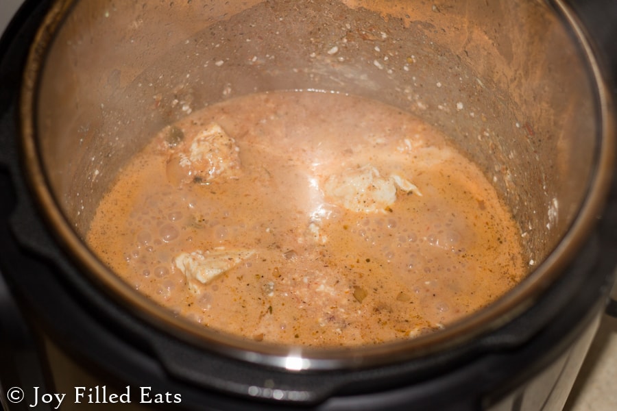 overhead view of an instant pot filled with cooking creamy salsa chicken
