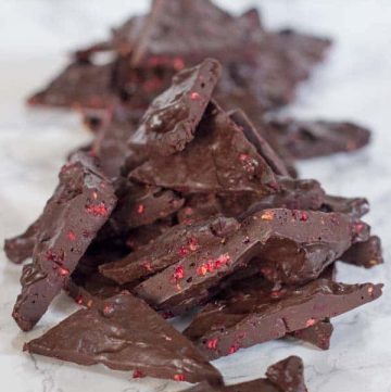 dark chocolate raspberry truffle bark lined in a pile on a marble surface