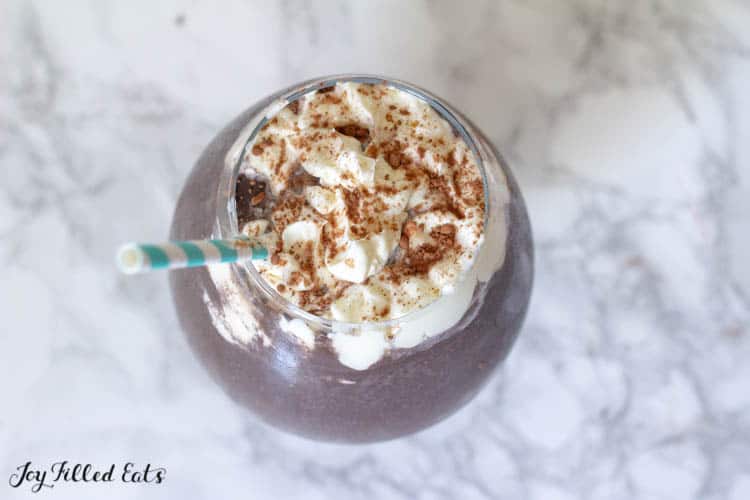 overhead view of frozen hot chocolate with whipped cream and paper straw