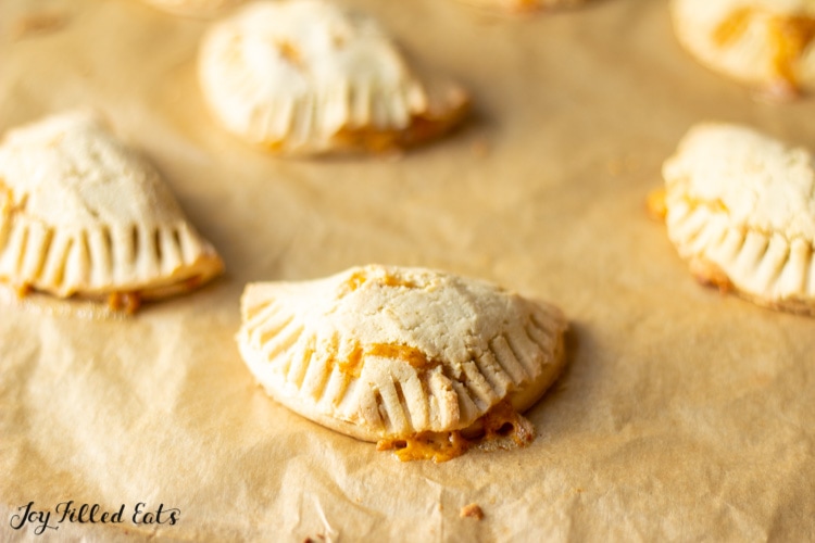 taco empanadas arranged on a parchment lined sheet pan from above