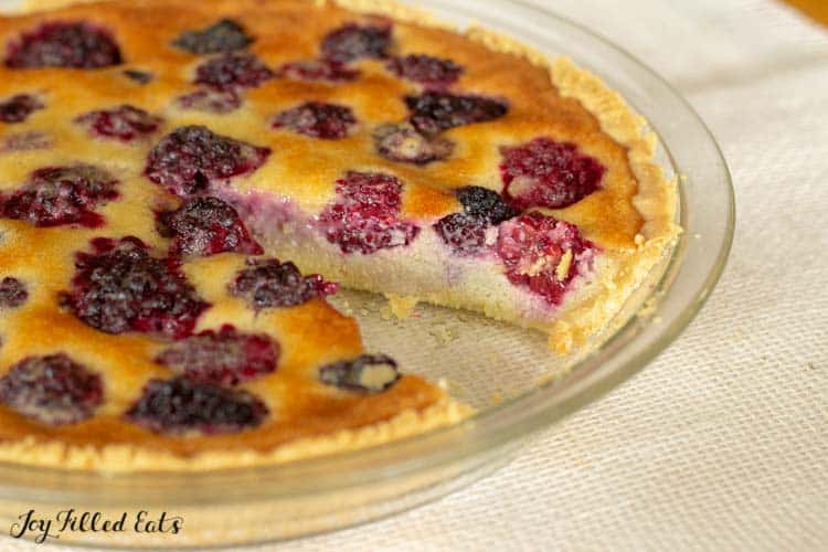 custard pie with blackberries with slice missing close up