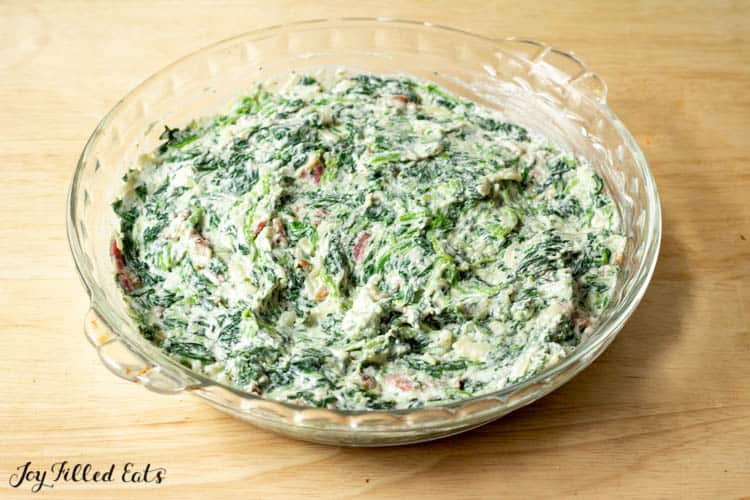 keto spinach dip in pie plate before baking and added extra bacon topping