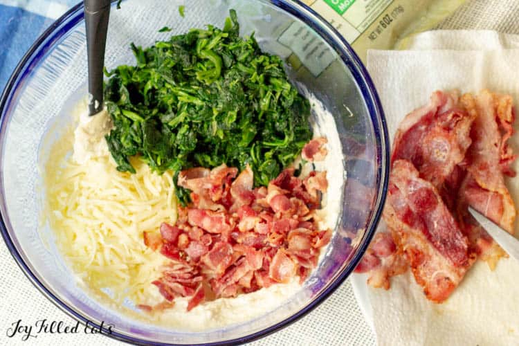 large mixing bowl of ingredients next to extra bacon pieces