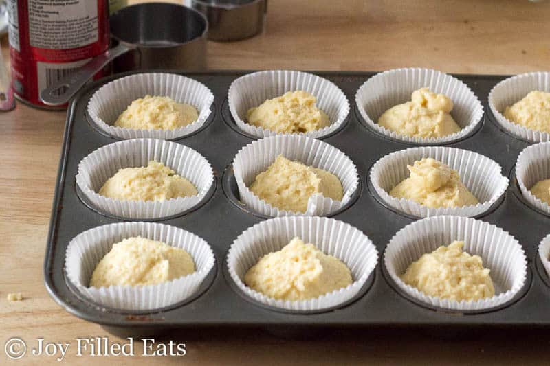 wrapper lined muffin tin filled with balls of cupcake batter
