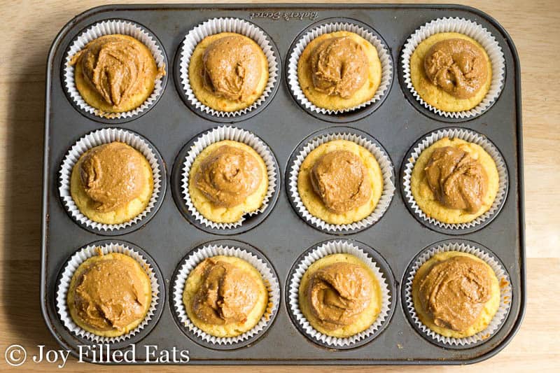 cupcakes topped with a peanut butter frosting filled in a cupcake tin