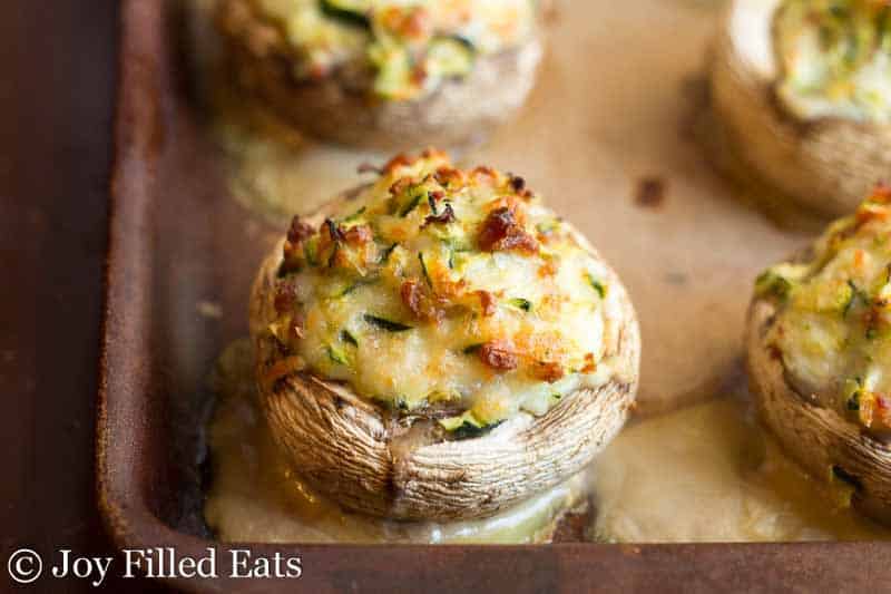 close up on cheese stuffed mushrooms with bacon on a sheet pan