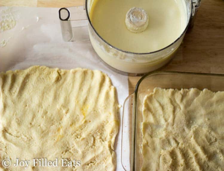 mozzarella dough rolled into two squares, one on parchment and one placed in a baking dish