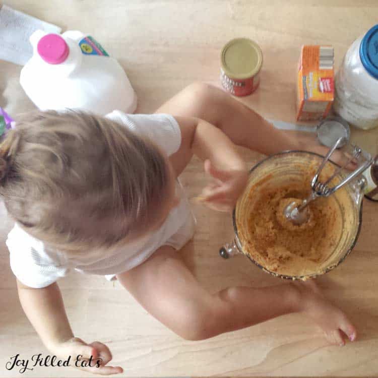child sitting and using finger to eat some peanut butter whoopie pie filling