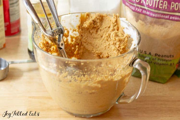 cookie batter for peanut butter whoppie pies in mixing bowl with ice cream scoop