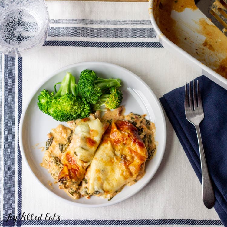overhead view of keto Tuscan chicken casserole served with broccoli florets on a white plate next to a fork