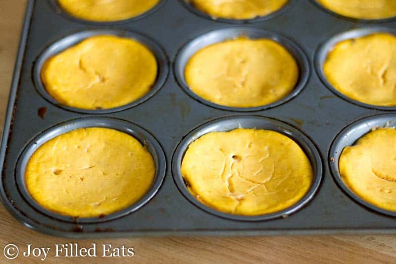 muffin tin filled with keto pumpkin breakfast cheesecakes with Pecan Crust