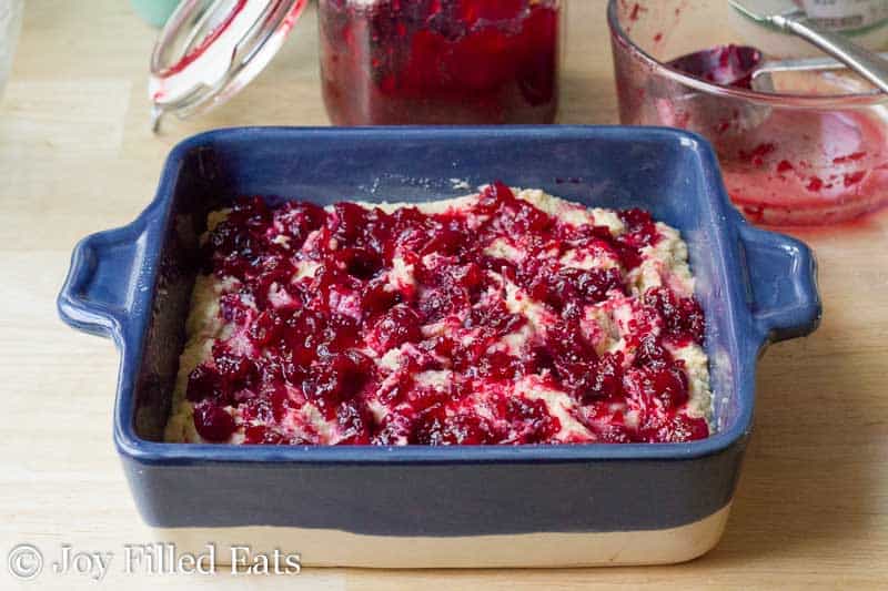 cranberry filling spread on top of cake batter within a casserole dish