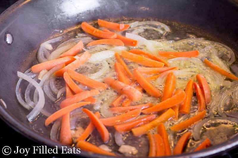 sauteing onion and carrot slices in a skillet