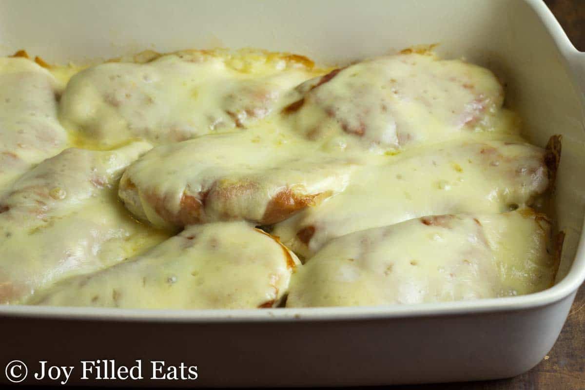 chicken breasts lined in casserole dish and topped with melted cheese