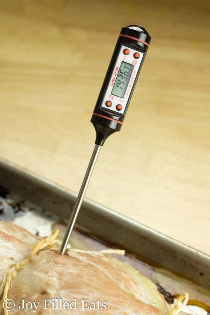 meat thermometer sticking into a stuffed pork marsala