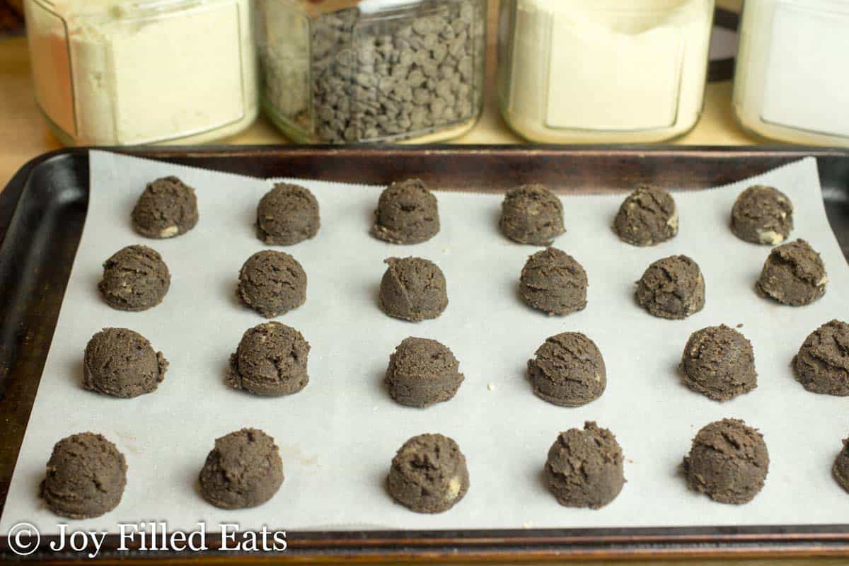 chocolate chip mocha cookie dough balls lined on a sheet pan
