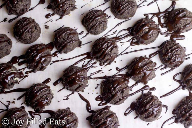 chocolate chip mocha cookies drizzled in melted chocolate arranged on a white surface from above