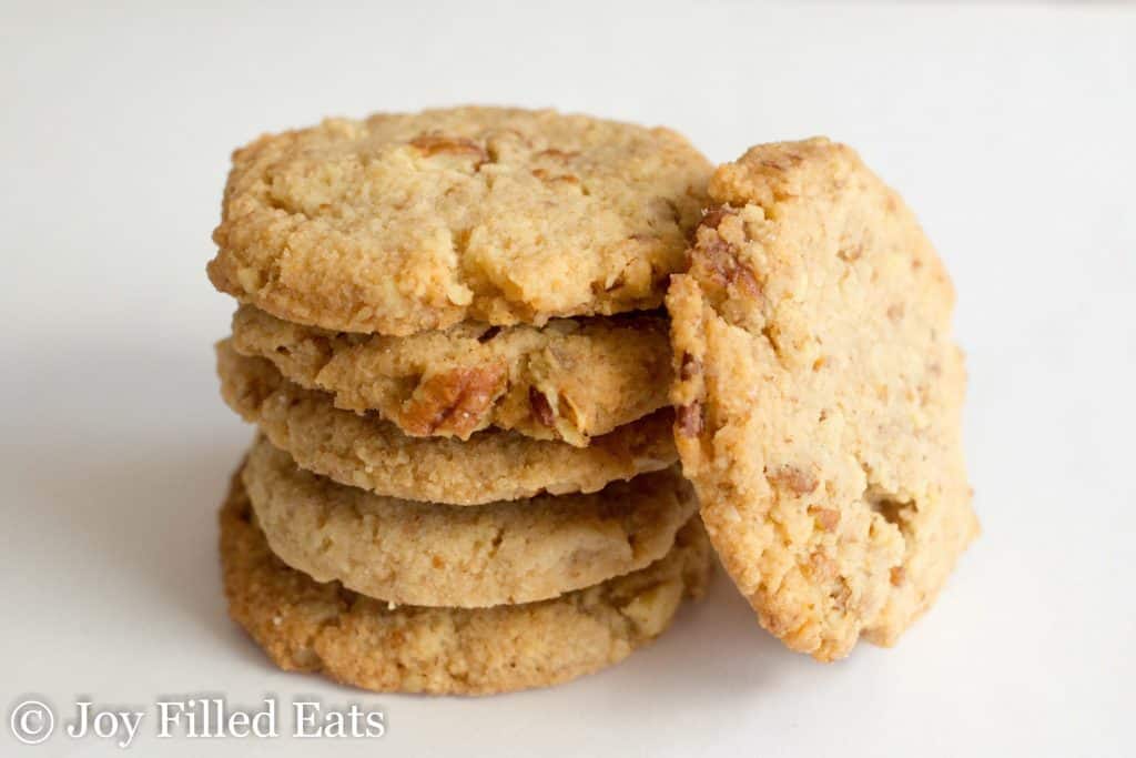 stack of butter pecan cookies with one cookie leaning on the stack