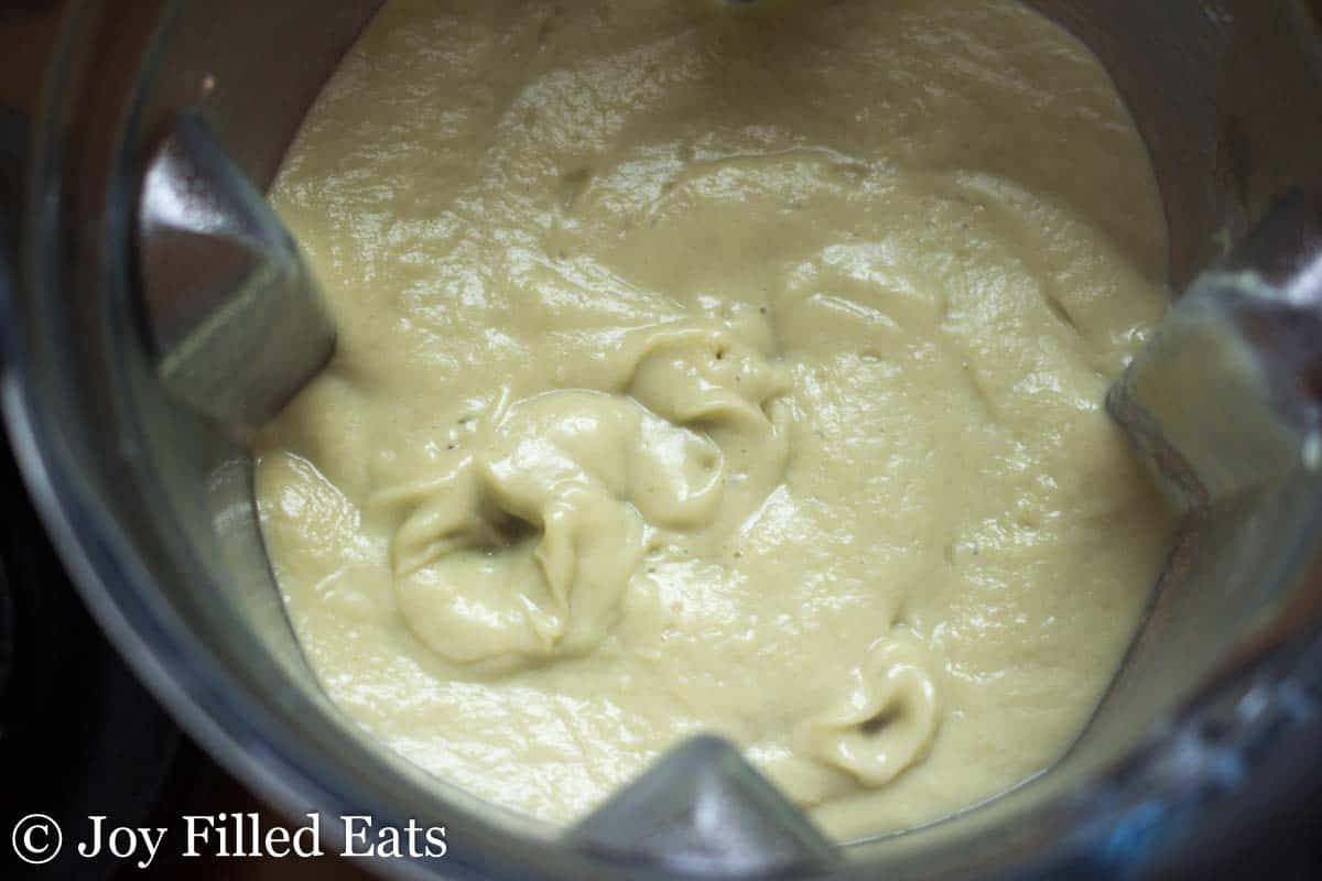 close up on creamy garlic soup in a blender