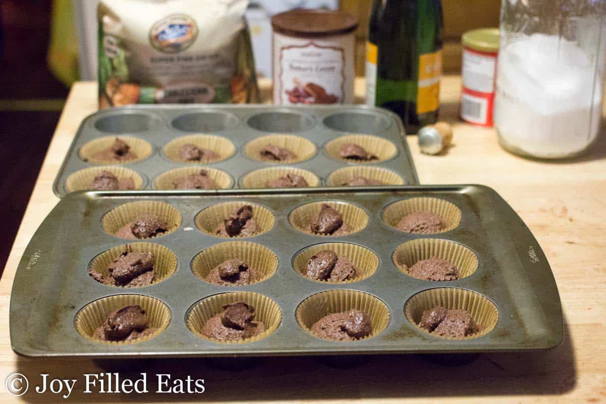 chocolate champagne cupcake batter spooned into wrapper lined muffin tins