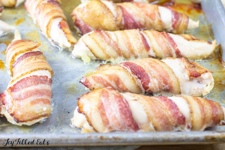 close up on bacon wrapped chicken tenders on a sheet pan