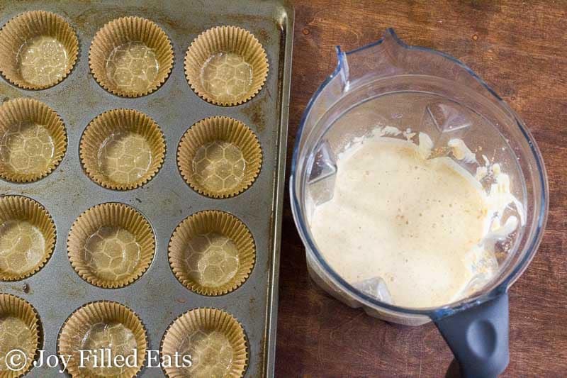 chai pancake batter in a blender next to a wrapper lined muffin tin