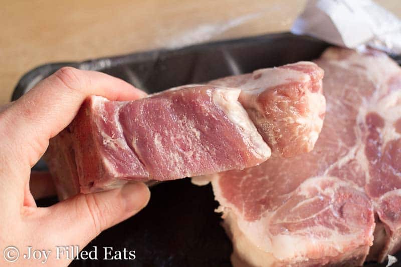 hand holding thick cut pork chop